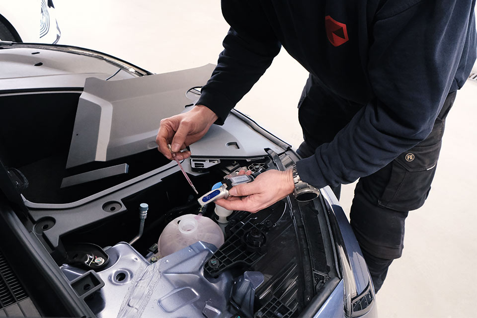 Mekaniker tjekker kølervæske på BYD elbil hos Skorstensgaard
