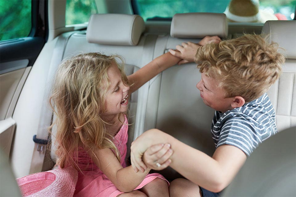 Børn leger på bagsædet af bilen