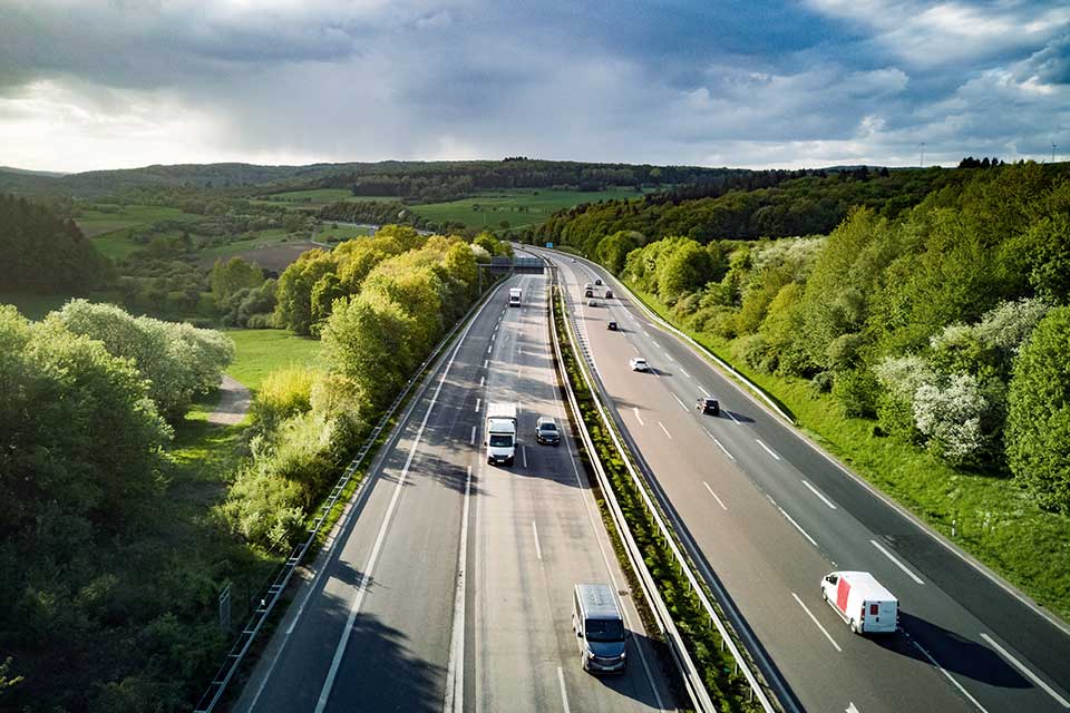 Biler kører på motorvej om sommeren i Tyskland