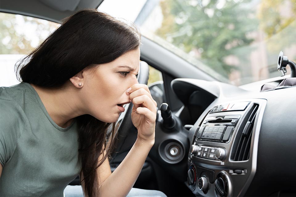Kvinde holder sig for næsen ved dårlig lugt i bilen