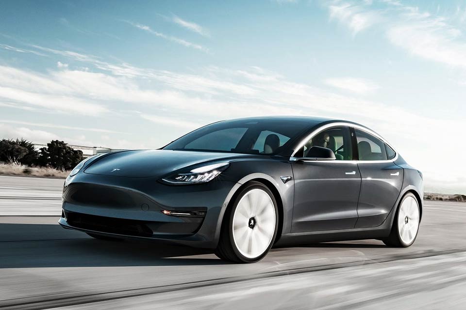 Mørkegrå Tesla Model 3 kører på vej