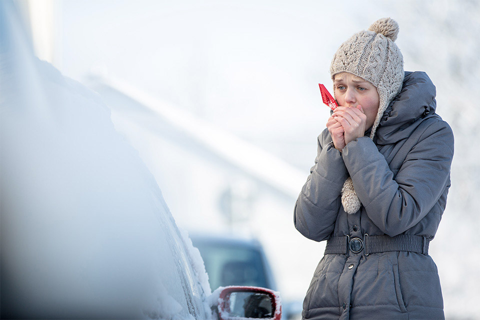 Kvinde skraber is af bilen om vinteren