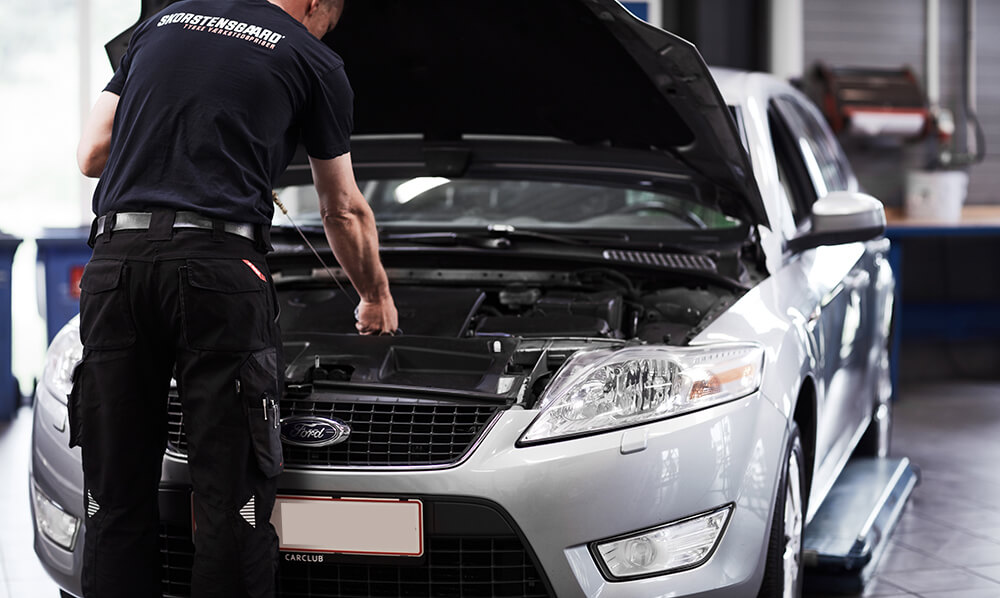 Mekaniker laver service på Ford bil på værksted